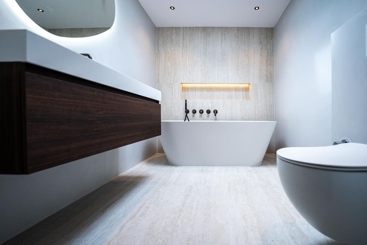Luxe interieur met vrijstaand bad, donker houten maatwerk en microcement